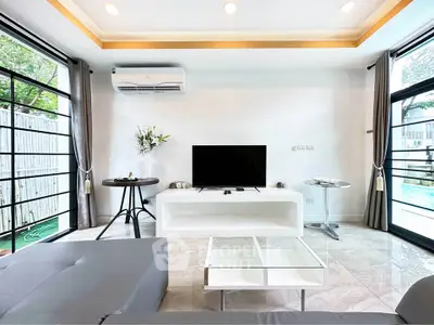 Modern living room with sleek furniture and large windows offering natural light.
