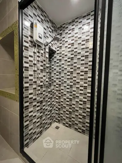 Modern bathroom with stylish tiled shower area and electric water heater.