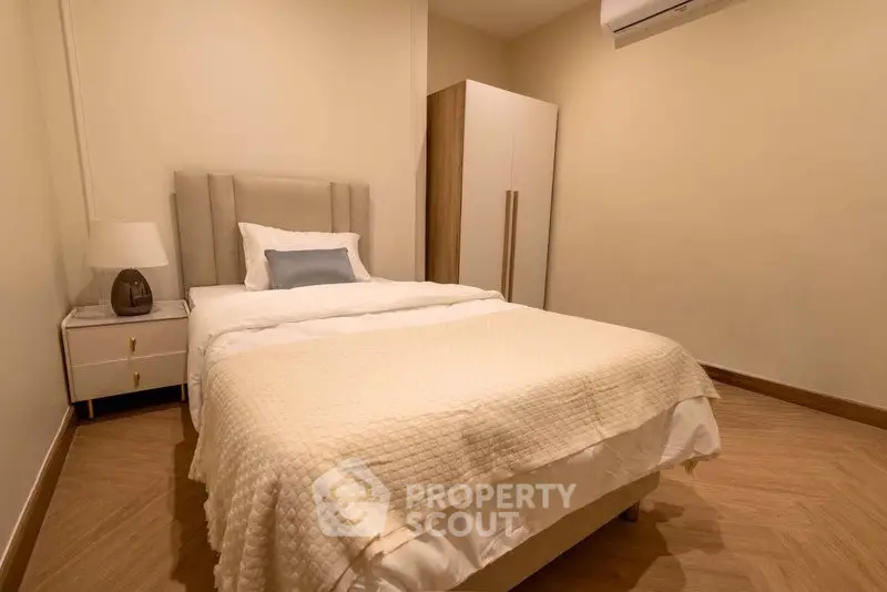 Cozy bedroom with modern furnishings and warm lighting, perfect for relaxation and comfort.