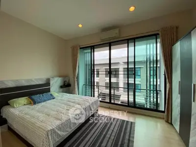 Spacious bedroom with modern decor and large windows offering natural light and a view.