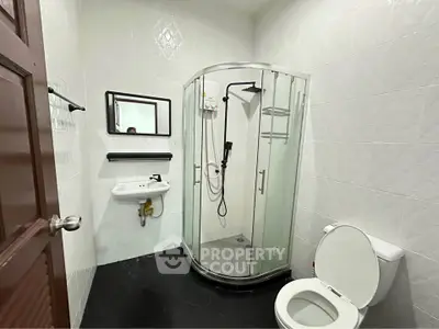 Modern bathroom with glass shower and sleek fixtures in a contemporary home.