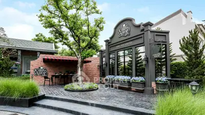 Charming coffee shop exterior with lush greenery and inviting outdoor seating area.