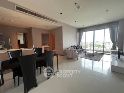 Spacious modern living room with open layout and large windows offering city views.