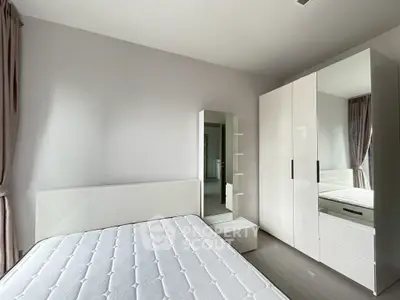 Modern bedroom with sleek white furniture and natural light