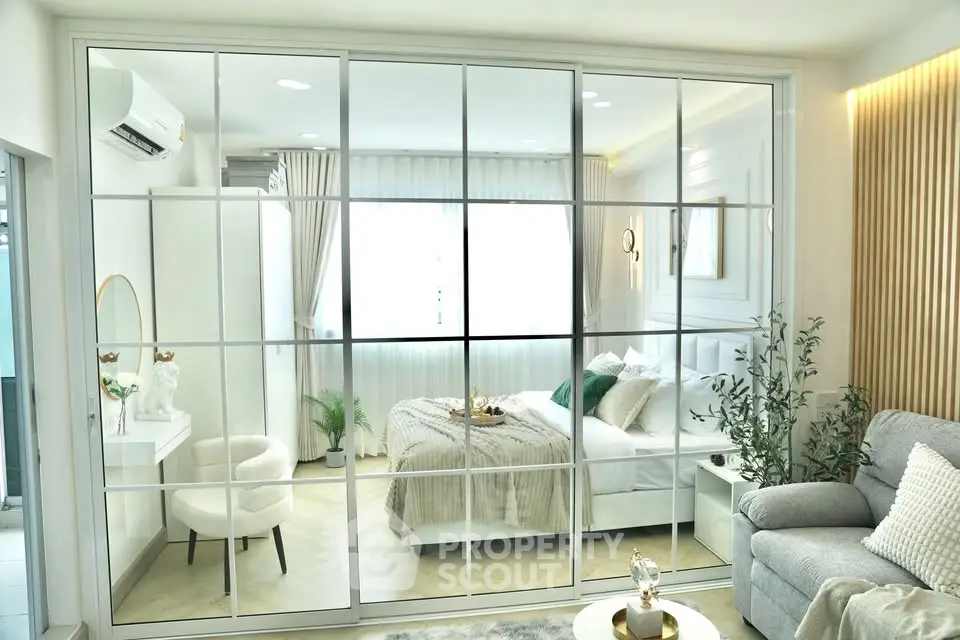Modern bedroom with glass partition, cozy decor, and natural light