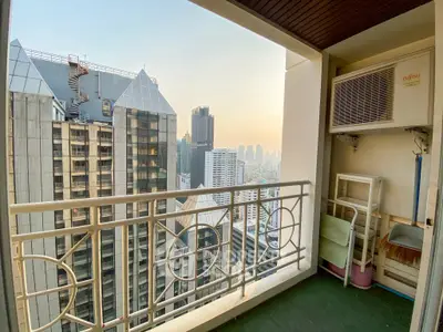 Stunning city view from a high-rise balcony with modern railing and air conditioning unit.