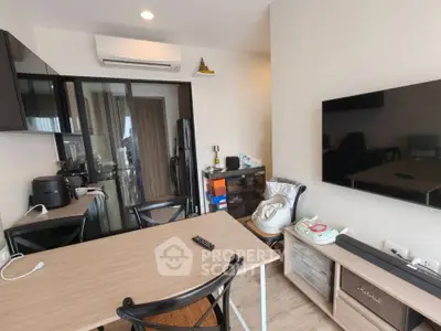 Modern living room with sleek furniture and wall-mounted TV in a cozy apartment.