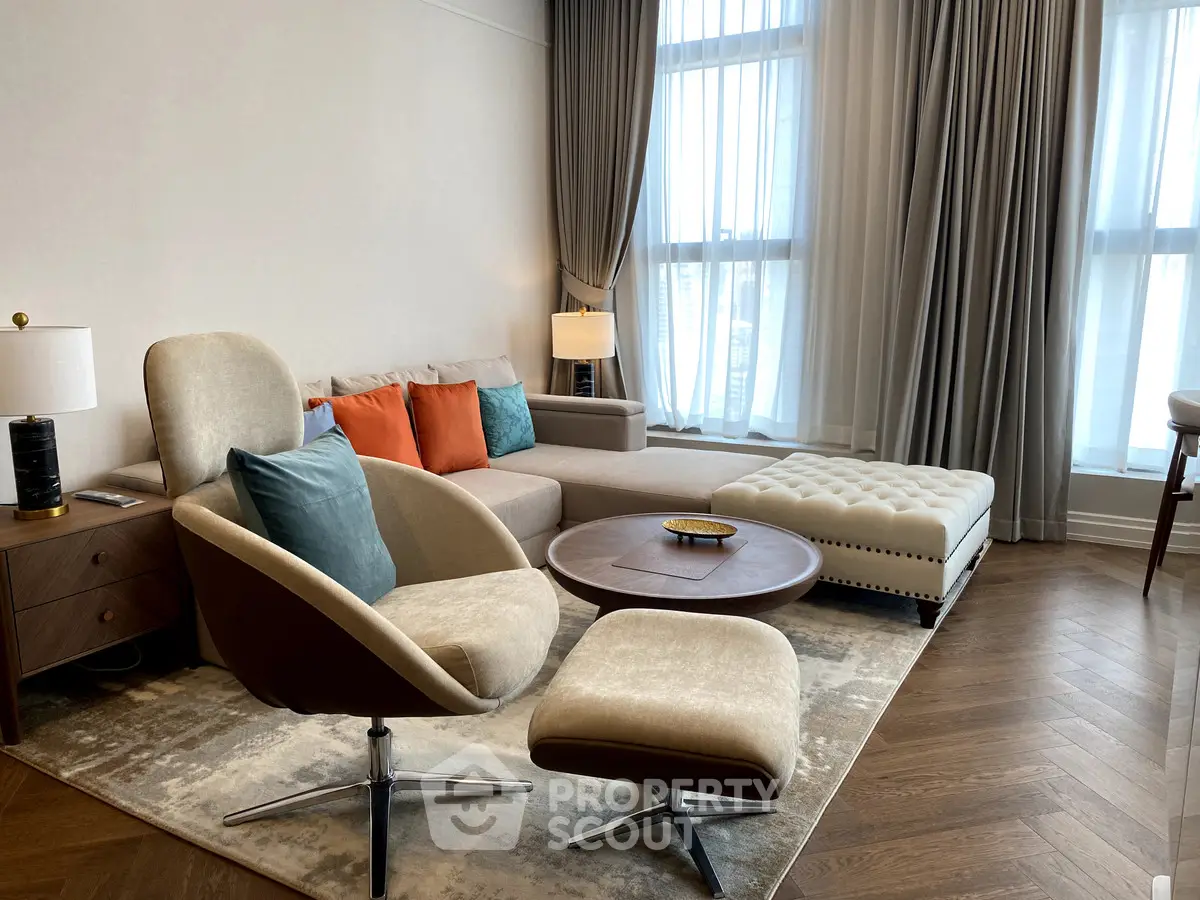 Luxurious living room with modern furniture and elegant decor, featuring a cozy seating area and large windows.