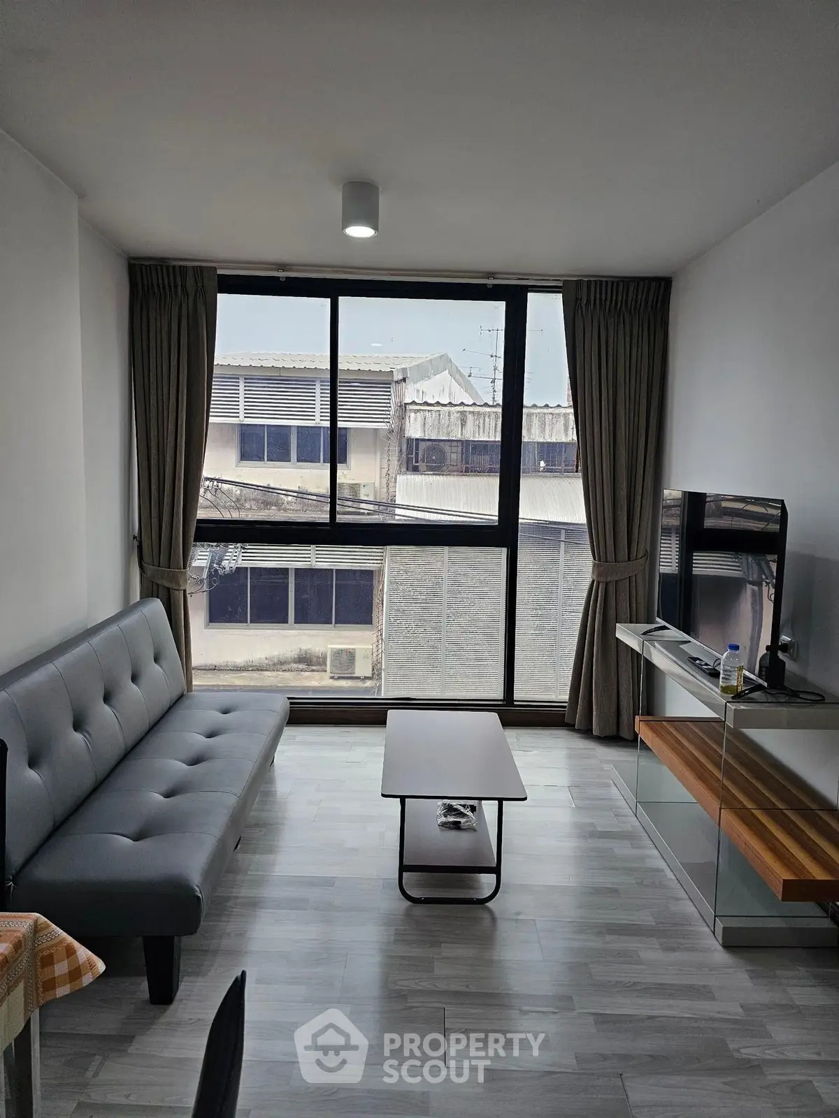 Modern living room with large window and stylish furniture in urban apartment