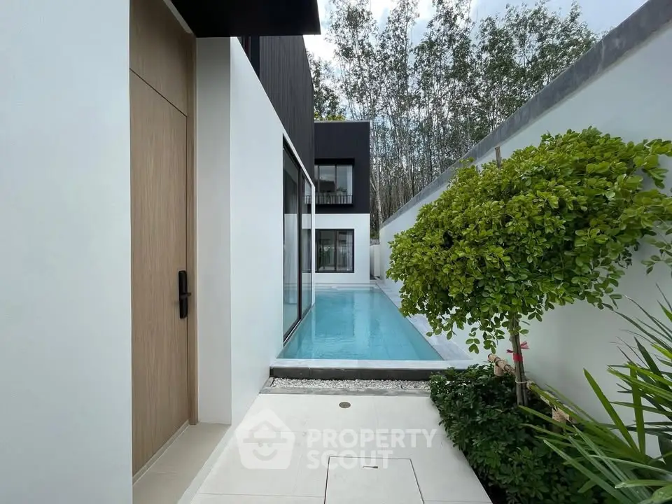 Modern luxury home with private pool and lush greenery, perfect for serene living.