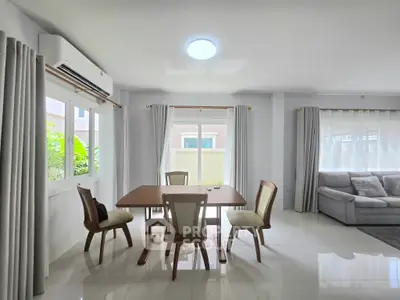 Spacious living room with elegant dining area and natural light, perfect for family gatherings.