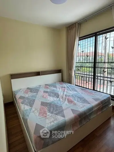 Cozy bedroom with large window and stylish bed in modern apartment