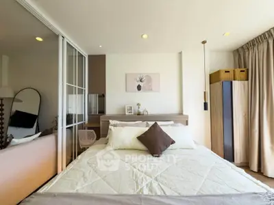 Modern bedroom with stylish decor and ample natural light, featuring a cozy bed and elegant furnishings.