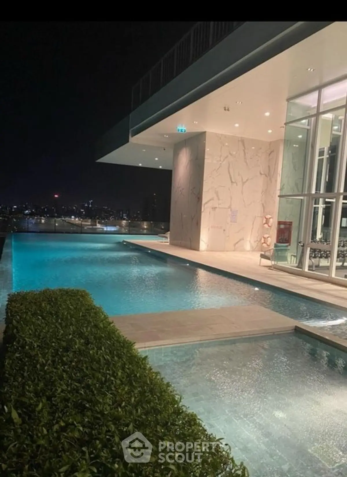 Luxurious rooftop pool with stunning city skyline view at night