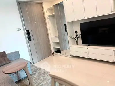 Modern living room with sleek furniture and large TV unit, showcasing contemporary design and comfort.