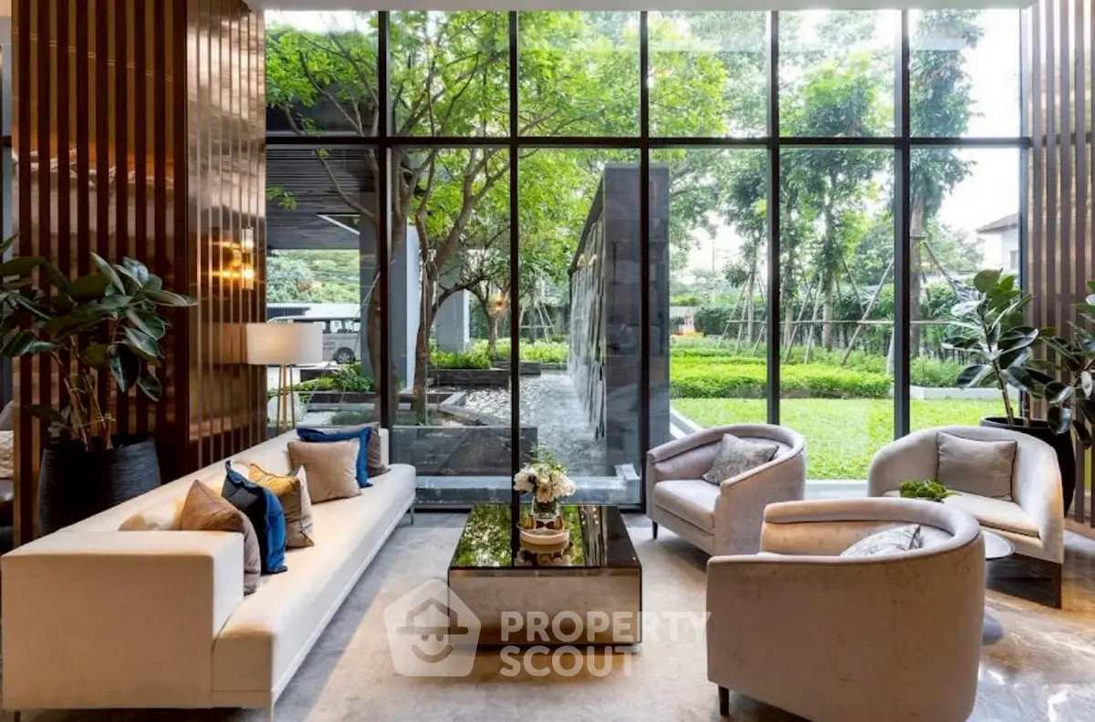 Luxurious living room with garden view, elegant furniture, and floor-to-ceiling windows.