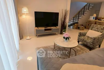 Stylish living room with modern decor and large TV, perfect for relaxation.