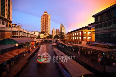 Stunning urban canal view with vibrant sunset and modern skyscrapers.