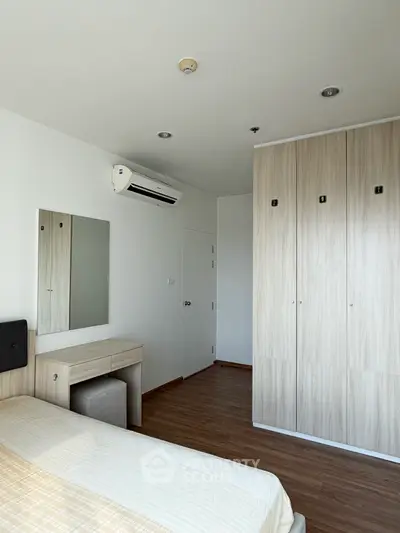 Modern bedroom with built-in wardrobe and air conditioning unit