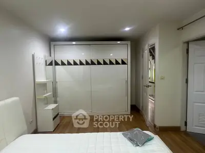 Modern bedroom with stylish wardrobe and wooden flooring