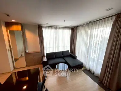 Modern living room with large windows and stylish furniture in a bright apartment.