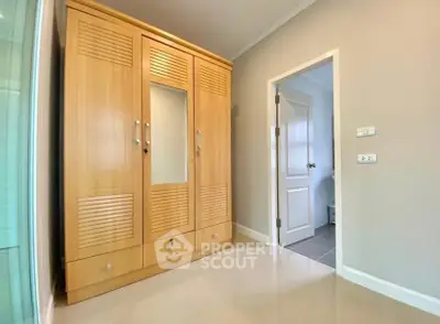 Spacious bedroom with elegant wooden wardrobe and sleek modern door