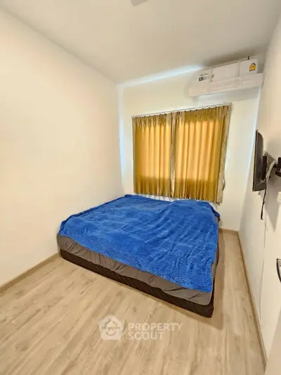Cozy bedroom with blue bedding and natural light through curtains