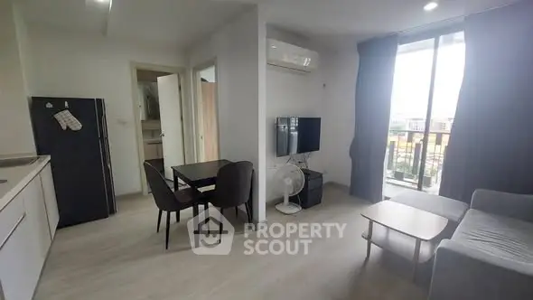 Modern living room with balcony, sleek furniture, and natural light in a stylish apartment.