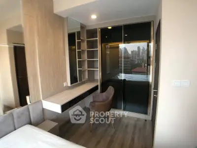 Modern bedroom with city view, featuring sleek built-in shelves and a stylish chair.