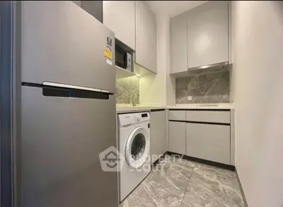 Modern kitchen with sleek appliances and stylish cabinetry in a compact layout.