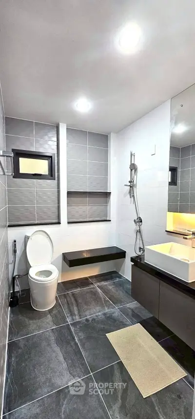 Modern bathroom with sleek design, featuring large tiles and contemporary fixtures.