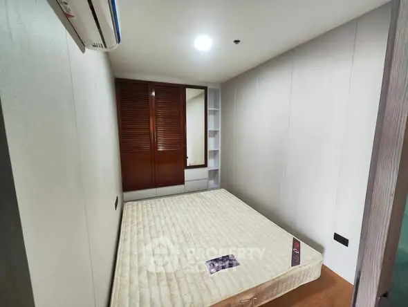 Cozy bedroom with built-in wardrobe and air conditioning, perfect for a restful retreat.