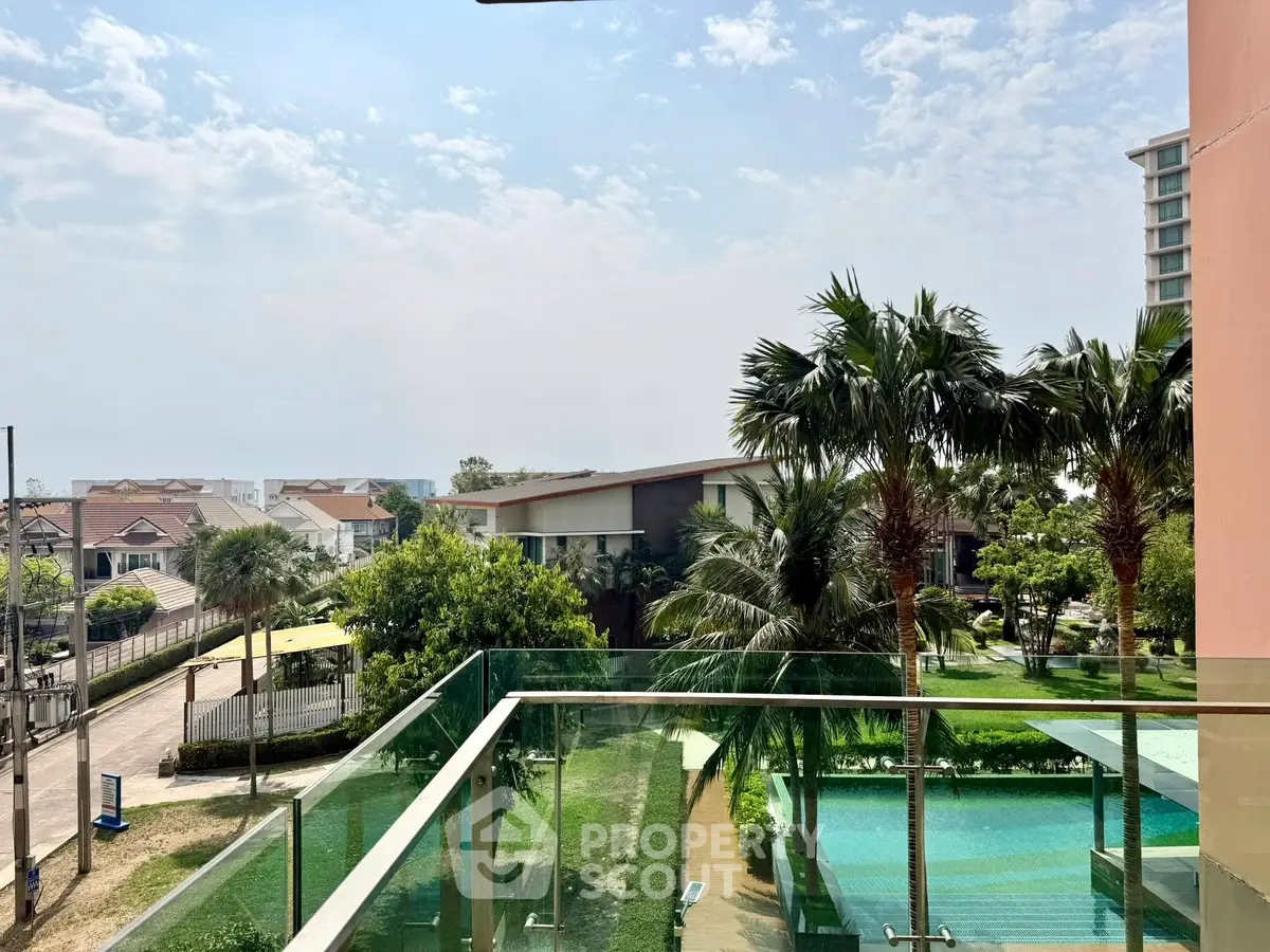 Stunning view from a modern balcony overlooking lush greenery and palm trees, perfect for relaxation.
