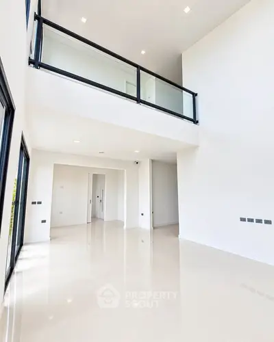 Spacious modern living room with high ceilings and large windows in a luxury apartment.