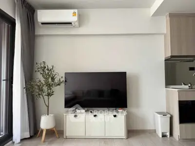 Modern living room with sleek TV setup and air conditioning in a stylish apartment.