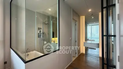 Modern apartment interior with glass-walled bathroom and city view