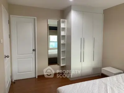 Modern bedroom with sleek white wardrobe and wooden flooring