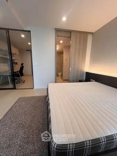 Modern bedroom with study area, featuring a comfortable bed and sleek design.