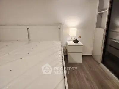 Modern bedroom with sleek white furniture and ambient lighting