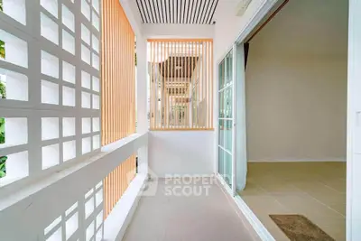 Charming balcony with modern design and sliding glass doors leading to a cozy interior space.