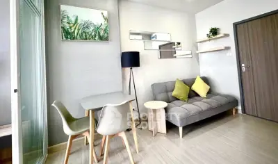 Modern living room with stylish decor, cozy sofa, and dining area in a contemporary apartment.