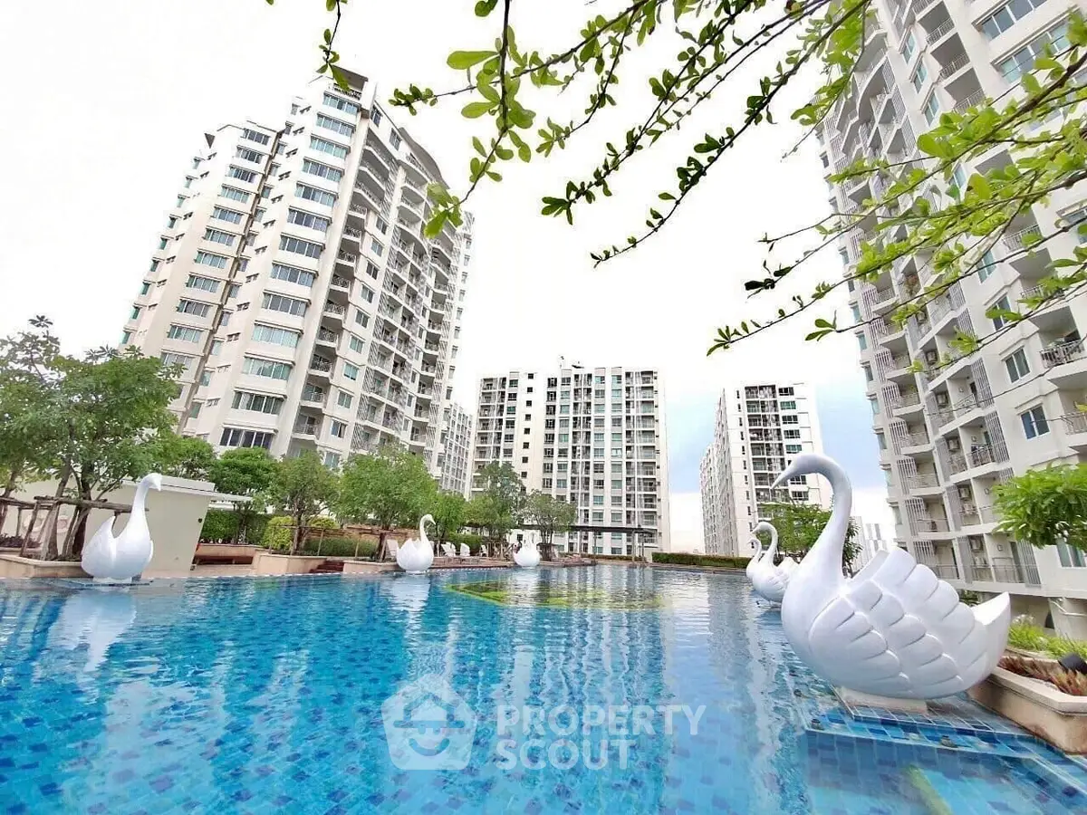 Luxurious apartment complex with stunning pool and swan sculptures.