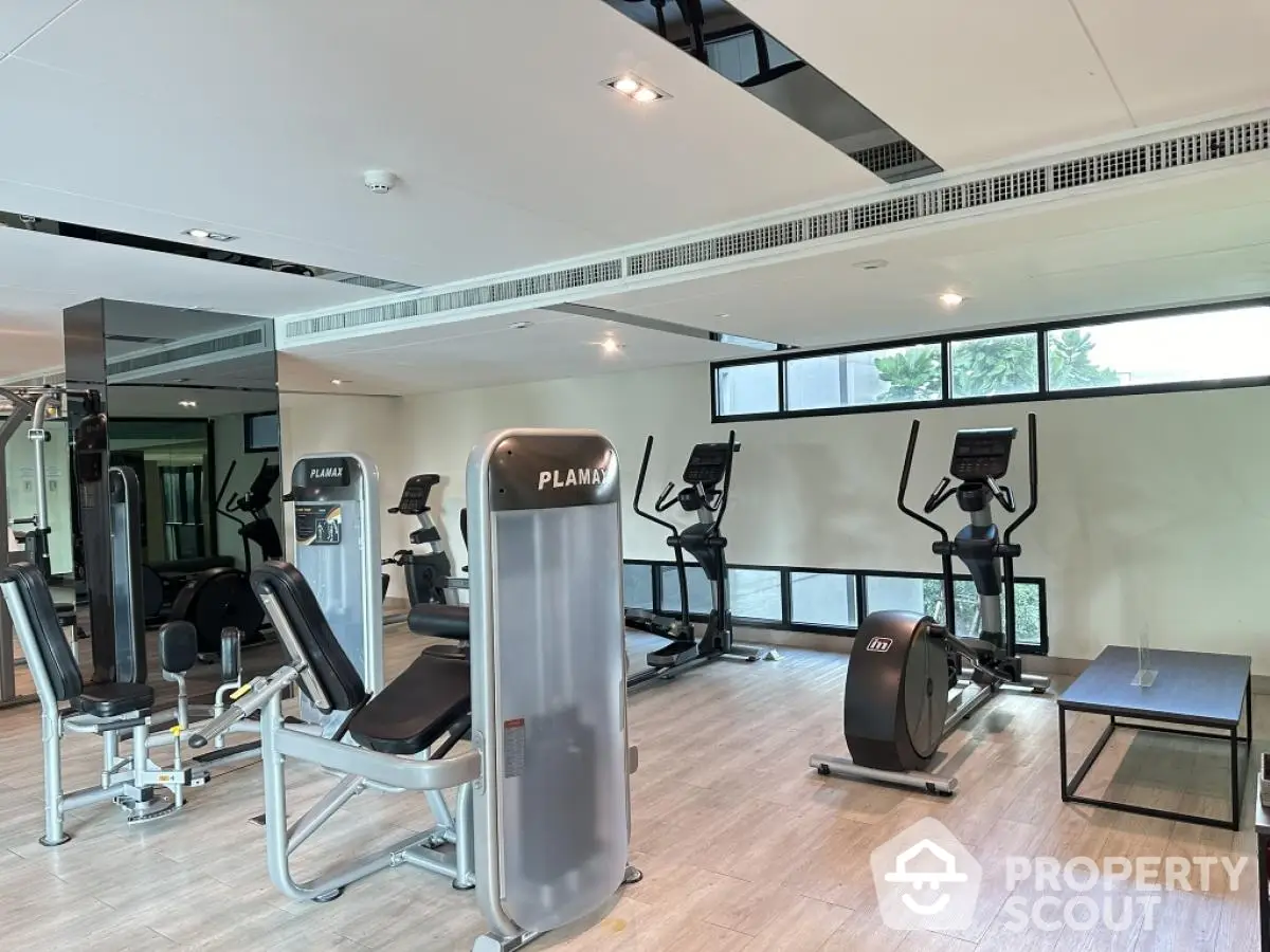 Modern gym with state-of-the-art fitness equipment and large windows for natural light.