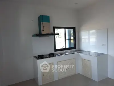 Modern kitchen with gas stove and sleek cabinetry in a bright, airy space.