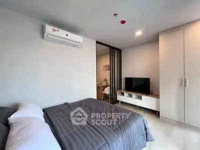 Modern bedroom with sleek design, featuring a cozy bed, air conditioning, and a TV unit.