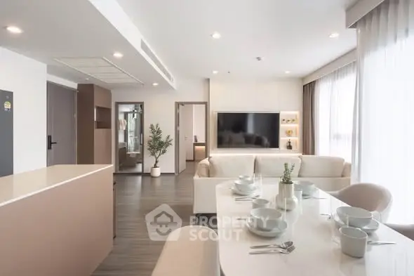 Spacious modern living room with elegant dining area and large TV, perfect for entertaining.
