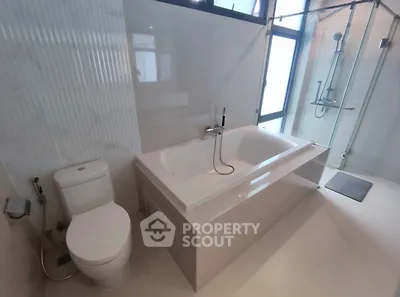 Modern bathroom with bathtub and glass shower enclosure