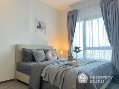 Elegant bedroom with large window and stylish decor, perfect for modern living.