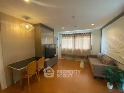 Modern living room with stylish decor, cozy sofa, and natural light through large windows.