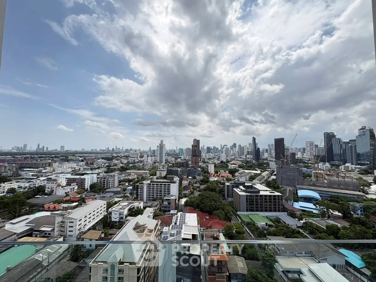 Stunning cityscape view from a high-rise balcony showcasing urban skyline and expansive sky.